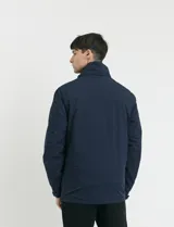Campera 2 en 1 azul marino con capucha desmontable, cierre frontal con solapa de botones a presión y bolsillos laterales con cierre.