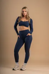 Conjunto deportivo azul marino compuesto por un top de mangas largas y calzas largas con bolsillos laterales.