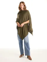 Poncho tejido de punto con diseño asimétrico y aberturas laterales para los brazos.