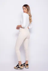 Pantalón chupín de tiro medio con textura similar al denim, en color beige claro.