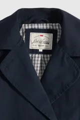 Campera tipo trench corta de corte amplio, color azul marino, con diseño de doble botonadura y cuello con solapas.