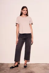 Remera color crudo de algodón peinado, de corte recto y mangas cortas. Presenta cuello redondo con detalle de cadena metálica dorada.