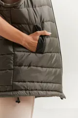 Chaleco verde militar con cierre frontal, bolsillos laterales y capucha forrada.