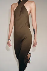 Vestido midi de punto color marrón, con diseño sin mangas, cuello halter cruzado y anudado, y espalda descubierta.
