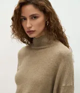 Suéter de punto de corte oversize y largo alargado, con cuello alto, mangas largas y aberturas laterales sutiles. Presenta puños y ruedo con acabado acanalado.