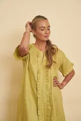 Vestido tipo túnica de lino color verde, manga corta con volados, escote en V y detalle de volados frontales verticales.