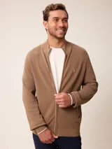 Cardigan de punto color marrón, con cierre frontal completo, cuello tipo bomber y puños acanalados con detalle en color crema.