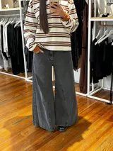 Jean de corte oxford con tiro medio-alto, confeccionado en algodón. Presenta un diseño de paneles con cortes verticales en dos tonos de azul y costuras marcadas en las piernas, ofreciendo una silueta amplia y fluida.