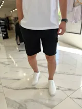 Bermuda cargo de jogging color beige, con bolsillos laterales y cordón ajustable en la cintura.