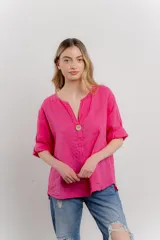 Blusa de lino color fucsia, de calce holgado y caída ligera. Presenta escote en V, mangas cortas y un detalle de botón de madera central.