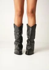 Botas texanas de cuero color crudo, con caña alta arrugada y punta fina.