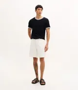 Remera de corte regular confeccionada en tejido texturizado de algodón y poliéster. Presenta cuello redondo y bordes de mangas con detalle de rayas contrastantes en blanco y gris.