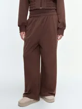 Pantalón deportivo de corte barrel y tiro medio, color marrón, con cintura elástica y bajo ajustable mediante cordón elástico.