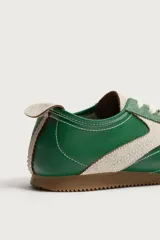 Zapatilla deportiva de estilo retro en color verde, confeccionada en una combinación de piezas de cuero y gamuza, con detalles a contraste en tono tostado y suela de goma dentada.