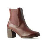 Bota tipo Chelsea de cuero negro con textura granulada, paneles laterales elásticos y taco cuadrado de altura media.
