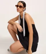 Vestido corto negro de malla punto roma, con escote halter y espalda descubierta. El ruedo es levemente evasé.