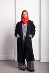 Tapado de paño color negro con cuello solapa, confeccionado en una mezcla de lana y fibras sintéticas. Presenta un diseño estructurado con detalles en cuero y forro parcial.