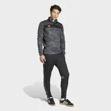 Pantalón de entrenamiento Adidas Tiro25 Essentials, color negro con logo de la marca bordado en naranja. Presenta un ajuste aerodinámico, cintura elástica con cordón y tecnología Aeroready para control de humedad.