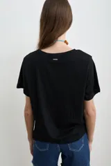 Remera negra de algodón con estampa frontal con la leyenda "COSA RARA" en color blanco, de corte holgado y mangas cortas.