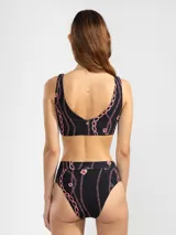 Top de bikini negro con estampado de cadenas y flores rosas.
