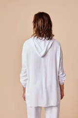 Sobrecamisa blanca de viscosa con capucha, cordón ajustable, bolsillos con apliques y botones metálicos.