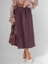 Falda midi de micro pana color morado oscuro, de corte recto y cintura elastizada. Incluye un cinturón desmontable de cuero marrón.