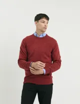 Sweater de tejido de punto con escote redondo y manga larga, con detalles de costuras en sisas y cuello. Presenta un diseño clásico y versátil.
