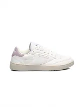 Championes Umbro modelo Rian, de diseño clásico en color blanco con detalles en rosado en el talón y logo lateral. Presentan suela de goma en tono crema y perforaciones en la puntera para mayor ventilación.
