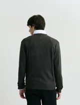 Sweater de punto con escote en V y manga larga, confeccionado en tejido acrílico con textura suave.
