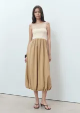 Vestido midi combinado con tirantes finos ajustables, escote recto y diseño con bajo abullonado estilo globo. Cuenta con cuerpo de punto en tono crudo y falda de tejido modal en tono tostado.