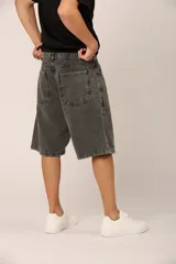 Bermuda gris oscuro de denim, corte ancho, con bolsillos laterales y traseros, y detalle de parches en las rodillas.