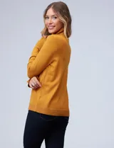 Polera de tejido fino, color rosado, con cuello alto, manga larga y detalle de tajo en los puños.