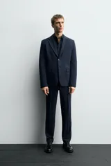 Blazer de corte slim fit confeccionada en tejido con viscosa, con cuello de solapas de muesca, manga larga con puños abotonados, bolsillo de vivo en el pecho, bolsillos con solapa en la cadera y cierre frontal con botones.