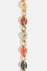 Pulsera de cadena con eslabones plateados y charms circulares esmaltados en diversos colores con logos grabados. Incluye un dije de corazón y cierre de mosquetón.