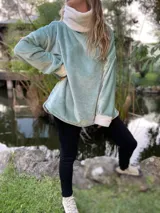 Polerón celeste de peluche con cuello alto y puños blancos.