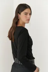 Remera negra de viscosa con cuello drapeado y mangas largas.