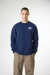 Buzo de cuello redondo color azul marino, con un pequeño gráfico impreso en el pecho izquierdo que incluye texto en inglés y japonés.