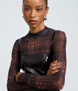 Vestido corto de poliuretano color marrón oscuro con efecto vinílico, de corte recto, escote cuadrado y tirantes finos. Cuenta con cierre de cremallera en la espalda.