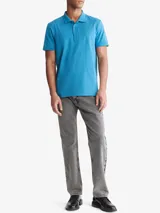 Chomba celeste de manga corta, confeccionada en mezcla de algodón y poliéster. Presenta cuello clásico con solapa de dos botones y logo de Calvin Klein bordado en el pecho.