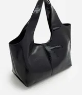 Cartera shopper grande Satinato de poliuretano color negro, con acabado texturizado brillante, diseño amplio y asa de hombro ancha.