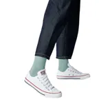 Zapatillas Converse Chuck Taylor All Star bajas, color blanco, con suela de goma blanca con detalles en rojo y azul.