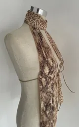 Top halter con estampado abstracto en tonos beige y marrón, con cuello alto y lazos ajustables en el frente.