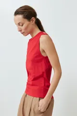 Musculosa de algodón color rojo, con cuello redondo, corte sin mangas y detalle de botones decorativos en los hombros.