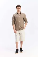 Camisa de manga larga con tejido texturado, cuello camisero y cierre frontal de botones. Diseño clásico y versátil.