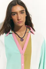 Collar con cordón azul marino y dije de flor calada con incrustaciones de strass azul y rojo.