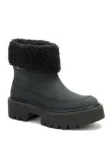 Bota de caña media color negro, confeccionada en nubuck, con cuello de pelo sintético y suela de plataforma dentada de goma.