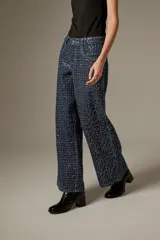 Pantalón jean ancho de tiro medio, completamente revestido con lentejuelas azul oscuro, de corte recto y cinco bolsillos.