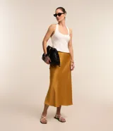 Pollera midi evasé de color beige claro, confeccionada en tela satinada de poliéster.