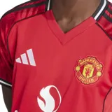 Camiseta de fútbol Adidas del Manchester United, modelo primera equipación temporada 25/26. Diseño rojo con detalles en negro y blanco en cuello y mangas. Incluye logo de Adidas, escudo del club y sponsor Snapdragon en el frente.