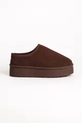 Zueco tipo mule de gamuza color marrón, con interior forrado en piel sintética y plataforma de goma dentada.